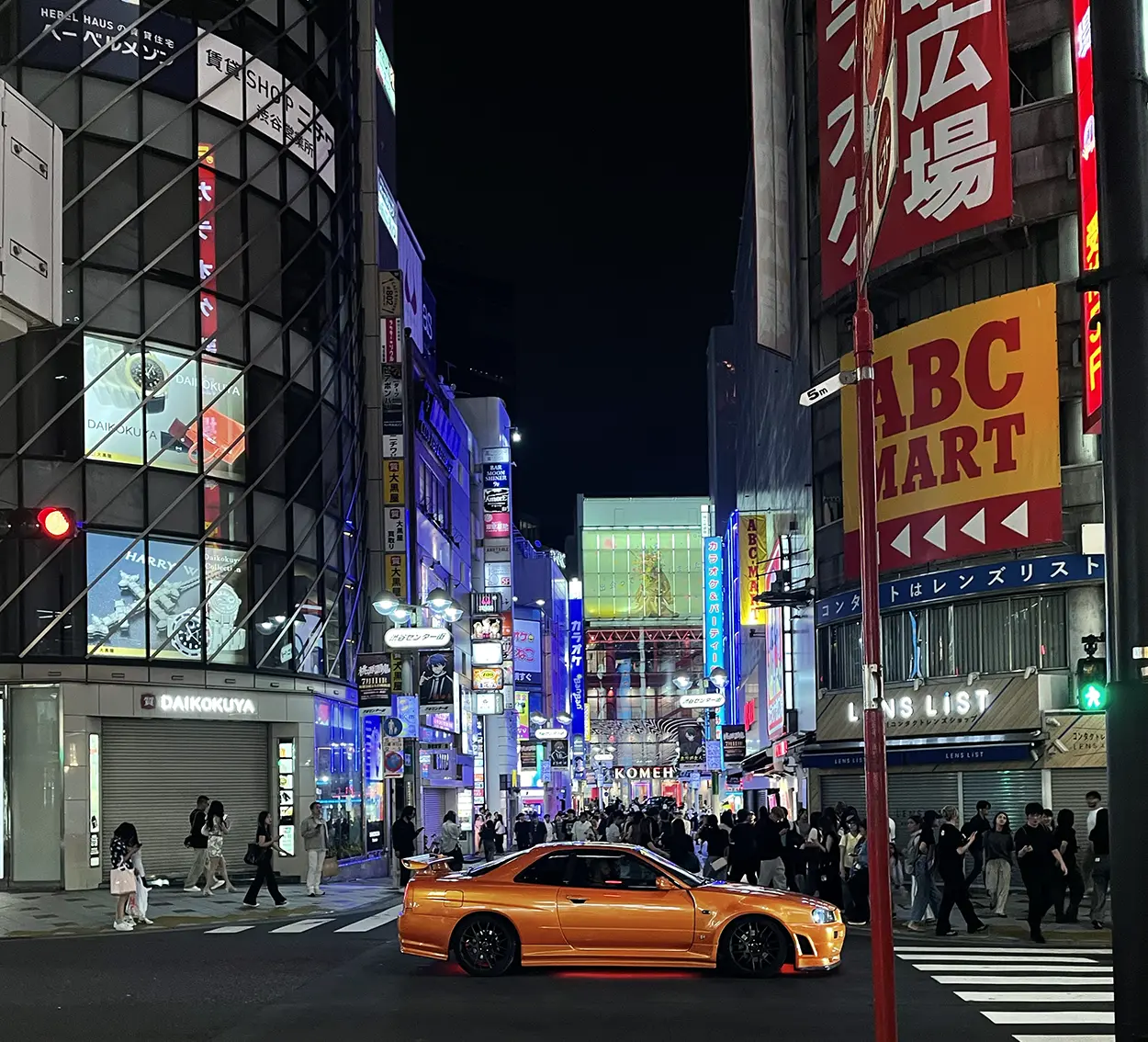 La nuit à Shibuya avec une voiture orange